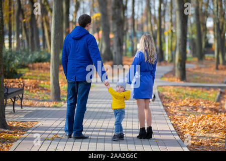 Familie auf einem Spaziergang. Mutter, Vater und Sohn gehen im Herbst Park. Stockfoto