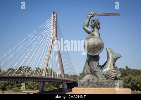 Bronze Skulptur des Warschauer Sirene am Ufer der Weichsel, Swietokrzyski-brücke auf der Rückseite, Åšwietokrzyski Brücke, Warschau, Polen Stockfoto