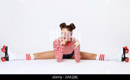 Schöne Frau in den Rollschuhen und mit roten Kopfhörer im Studio Stockfoto