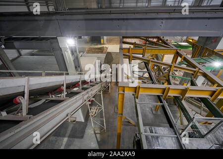 Das Förderband der Zutaten in den Mixer. Arbeiter in der Werkstatt des Hauses - Gebäude. Industrial Interior. Betonwerk. Stockfoto