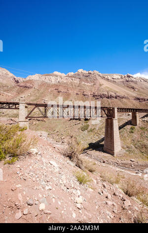 Eisen bahn Brücke über den Fluss Mendoza auf der Gebirgskette der Anden in der Nähe von Puente del Inca in der Provinz Mendoza, Argentinien Stockfoto