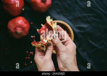 Mädchen reinigt die Frisch rot saftige Granatapfel in der Frame nur weibliche Hände Stockfoto