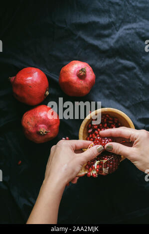 Mädchen reinigt die Frisch rot saftige Granatapfel in der Frame nur weibliche Hände Stockfoto