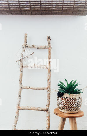 Home Schild auf einer Holzleiter neben einem Blumentopf auf einem Hocker Stockfoto
