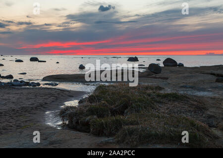 Sonnenuntergang Himmel über Steine und Flat Rock unter Ostsee sinkt. Fantastische Wildnis von Estland. Stockfoto