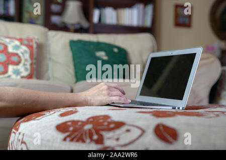 Frau, die Sie auf Ihrem Laptop an ihrem Haus. Von zu Hause aus arbeiten oder flexi Arbeit leben Konzept. Stockfoto