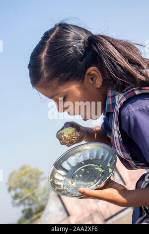 Sijhora, Madhya Pradesh, India-November 19, 2019: Nahaufnahme, Porträt cute Indian School Girl Essen. in Indien Stockfoto