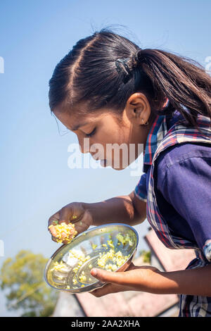 Sijhora, Madhya Pradesh, India-November 19, 2019: Nahaufnahme, Porträt cute Indian School Girl Essen. in Indien Stockfoto