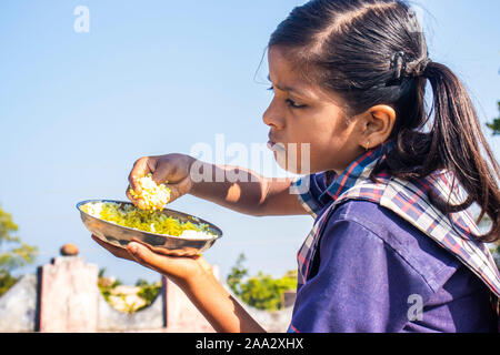 Sijhora, Madhya Pradesh, India-November 19, 2019: Nahaufnahme, Porträt cute Indian School Girl Essen. in Indien Stockfoto