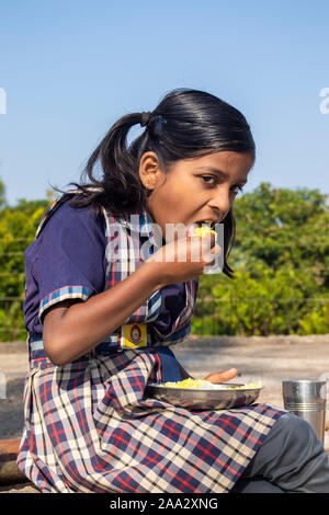 Sijhora, Madhya Pradesh, India-November 19, 2019: Nahaufnahme, Porträt cute Indian School Girl Essen. in Indien Stockfoto