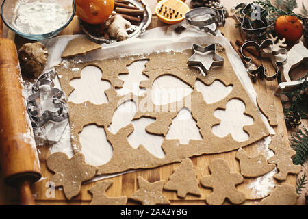 Lebkuchen Teig mit Metall Fräser in verschiedenen Formen für Weihnachtsplätzchen und Holz- Rolling Pin, Anis, Ingwer, Zimt, Tannenzapfen, tanne Zweig Stockfoto
