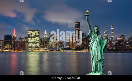 Freiheitsstatue vor der Skyline von Manhattan, in der Nacht, während der blauen Stunde Stockfoto