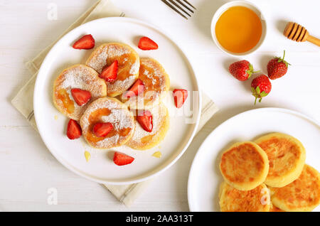Quark Pfannkuchen mit Erdbeeren Schichten und Honig. Gesundes Frühstück. Ansicht von oben, flach Stockfoto