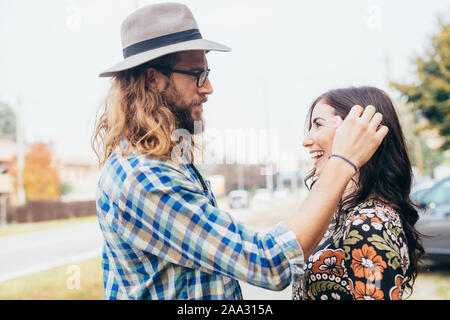 Junger Mann mit Blumen im Haar von seiner Freundin - Romantik, Zärtlichkeit, Liebe Konzept Stockfoto