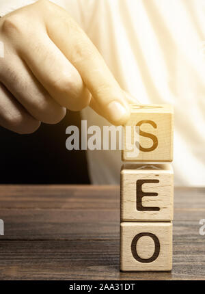 Blöcke mit dem Wort SEO und Geschäftsmann. Search Engine Optimization. Die Qualität und Quantität der Web site Verkehr erhöhen, indem Sie die visibilit Stockfoto