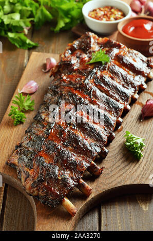 Pikanten gegrillte Spareribs auf ein Schneidbrett, Nahaufnahme Stockfoto
