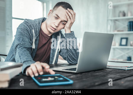 Traurig freudlos Mann vor dem Laptop sitzen Stockfoto