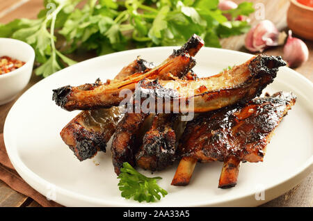 Köstliche gegrillte Schweinerippchen auf weiße Platte, die Ansicht zu schließen. Leckere bbq-fleisch Stockfoto