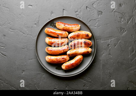 Bratwurst über schwarzen Stein Hintergrund. Ansicht von oben, flach Stockfoto