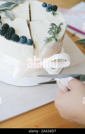 Frau zusammen binden vier Scheiben Kuchen eine zusammengesetzte Kuchen zu machen Stockfoto