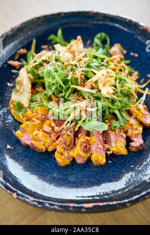Gebratenes Rindfleisch, Gemüse, Karotte und Austernsauce. In Scheiben geschnitten gegrilltes Rindfleisch Grill Roastbeef Steak und Salat mit Rucola. Stockfoto