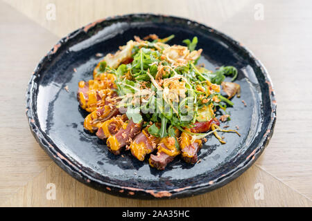 Gebratenes Rindfleisch, Gemüse, Karotte und Austernsauce. In Scheiben geschnitten gegrilltes Rindfleisch Grill Roastbeef Steak und Salat mit Rucola. Stockfoto