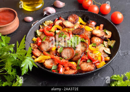Scheiben von gebratene Würstchen mit Gemüse und Gewürze in der Pfanne, bis in der Nähe Stockfoto