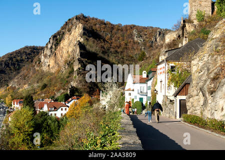 Menschen zu Fuß entlang der Bergstrasse zu den modernen Teil von Durnstein, Österreich, mit den Bergen im Hintergrund Stockfoto