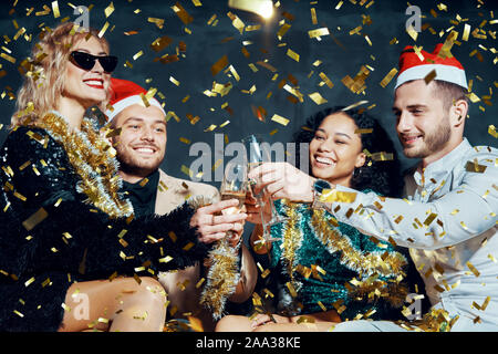 Multiethnischen gerne Freunde Toasten mit Champagner feiern Weihnachten oder Neujahr, gratulieren einander und geniessen. Feier und Che Stockfoto