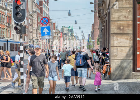 , Dam Square Amsterdam, Niederlande 27.07.2019, Damrak/de Bijenkorf auf dem Dam Platz im Sommer, blauer Himmel Stockfoto