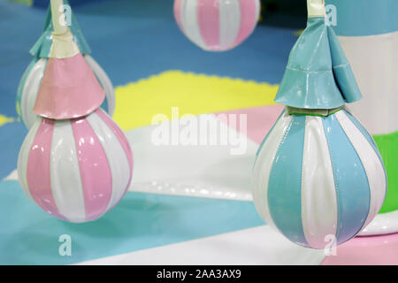 Merry-go-round Attraktion für Kleinkinder auf dem Spielplatz. Pear-shaped weichen Sitze farbige in Rosa und Blau. Unterhaltung für glückliche Kinder. Stockfoto