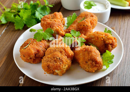 Gegrillte Chicken Wings, Sauce und frische Petersilie auf hölzernen Tisch Stockfoto