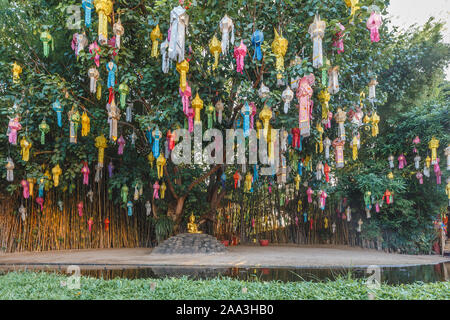 Bunte Laternen auf Bäumen und einem goldenen Buddha Statue im Wat Phan Tao während der Chiang Mai Laternenfest, Loi Krathong Festival Stockfoto