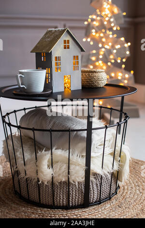 Nahaufnahme von Papier Haus und zwei leeren Becher auf einem Schwarzen Tisch und eine Tanne von holzbohlen für den Hintergrund. Stockfoto