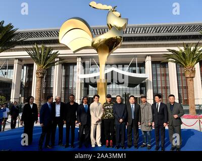 (191119) - XIAMEN, November 19, 2019 (Xinhua) -- Gäste posieren für Fotos mit einem symbolischen goldenen Hahn Skulptur für das 28. China Golden Rooster und Hundert Blumen Film Festival in Xiamen, im Südosten der chinesischen Provinz Fujian, 19.11.2019. Insgesamt 28 ausländische Filme, zusammen mit über 50 chinesischen filmischen Arbeiten, werden im Laufe des 28. China Golden Rooster und Hundert Blumen Film Festival, das ab Dienstag in Xiamen gekickt werden vorgestellt. (Xinhua / Jiang Kehong) Stockfoto