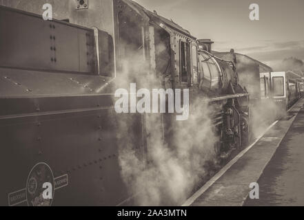 Vintage UK Dampfzug wartet auf Plattform ablassen Dampf, Crew in Lokomotive Taxi, Severn Valley Heritage Railway Kidderminster. B&W. Stockfoto