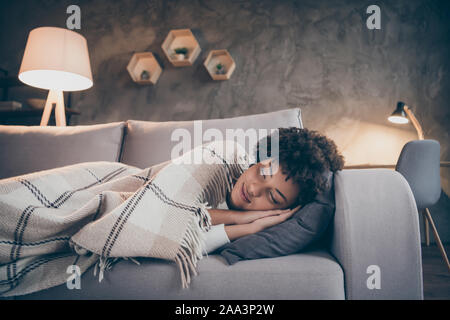 Portrait von positiven verträumt afro-amerikanische Mädchen schlafen Divan Traum mit karierten weiche Decke drinnen im Haus Zimmer abgedeckt Stockfoto