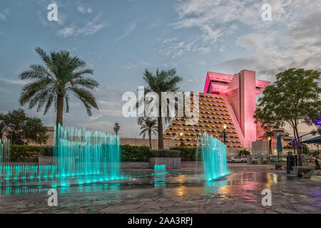 Sheraton Al Doha Hotel Außenansicht Tageslicht mit beleuchteten Brunnen im Vordergrund und Wolken im Himmel im Hintergrund Stockfoto