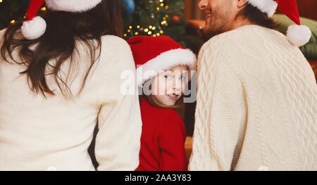 Kleines Mädchen in Santa Hut, von der Kamera über die Schulter Stockfoto