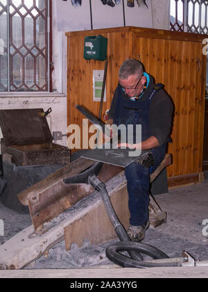 Demonstrator zeigen, wie Kammer an einen Schiefer fliesen Slate Museum in Gilfach Ddu im 19. Jahrhundert workshops der jetzt stillgelegten Dinorwic Schiefer q entfernt Stockfoto