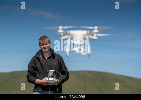 Teenager, die ein dji-Drohne in einer ländlichen Umgebung, Cumbria, Großbritannien. Stockfoto