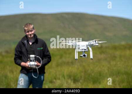 Teenager, die ein dji-Drohne in einer ländlichen Umgebung, Cumbria, Großbritannien. Stockfoto