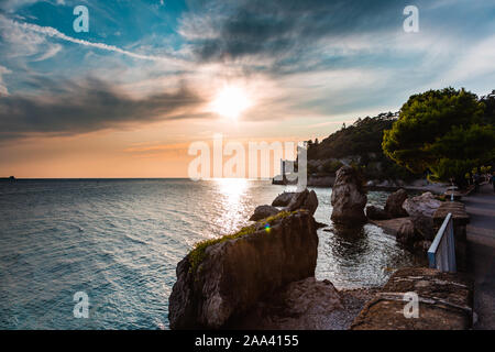 Dramatische Sicht auf das Mittelmeer Küste von Triest in Italien beim Sonnenuntergang, mit dem Schloss Miramare (Castello di Miramare) im Hintergrund. Stockfoto