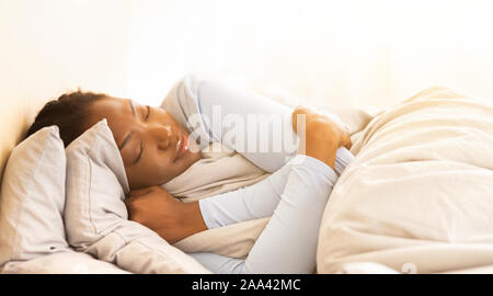 Afro Girl Schlafen umarmen Decke im Schlafzimmer im Morgen, Panorama Stockfoto