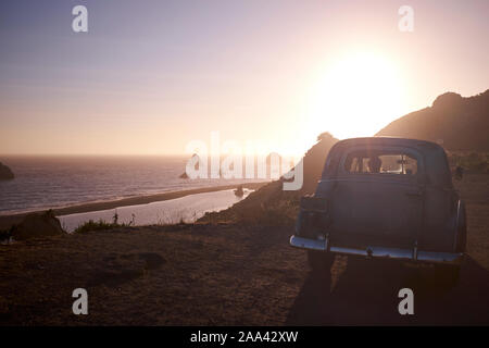 California Dreaming - ein klassisches Auto bei Sonnenuntergang, wo die russischen Fluss den Pazifischen Ozean, Oregon, USA erfüllt. Stockfoto