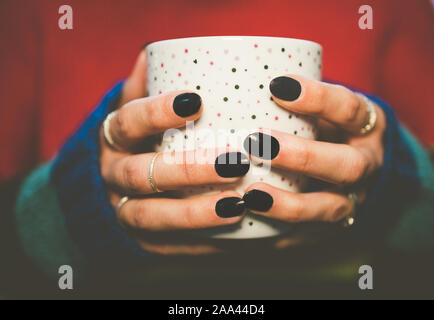 Nahaufnahmen der Hände einer Frau mit einem Becher Stockfoto