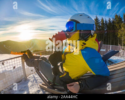 Frau trinkt heißen Tee auf der Oberseite der Winter Hill mit Blick auf Sonnenuntergang Stockfoto