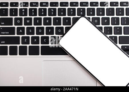 Mit leerer Bildschirm liegend über Laptop Tastatur Smartphone Stockfoto