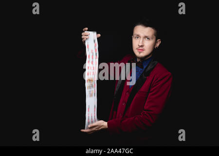 Magier zeigt Fokus mit Karten auf schwarzen Hintergrund. Stockfoto