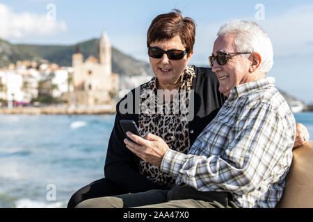 Zwei Senioren mit einem mobilen in Sitges, Spanien Stockfoto
